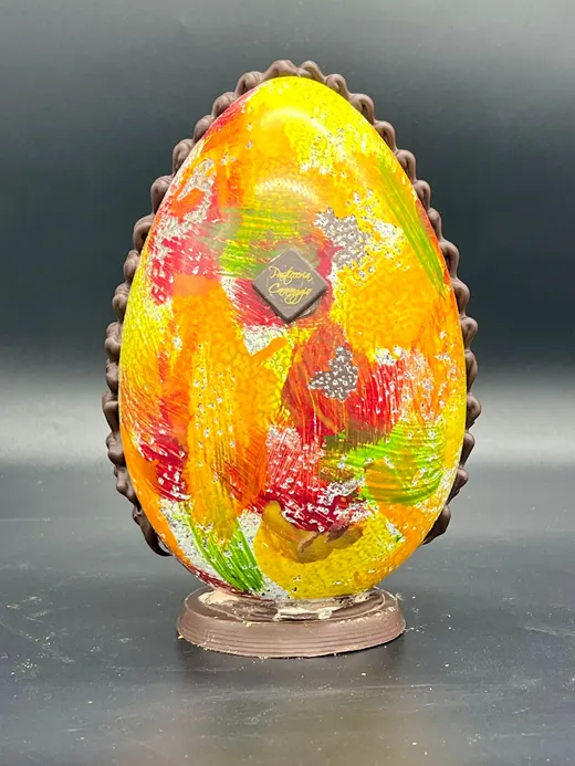 Uovo di cioccolato dipinto a mano con fiori arancioni