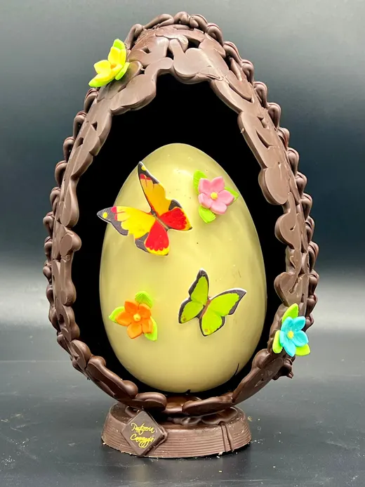 Uovo di cioccolato fondente con farfalle e fiori